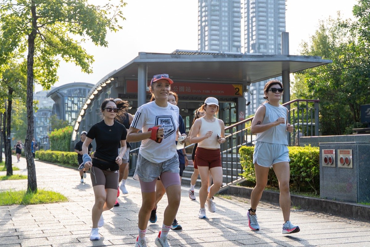 一群跑者沿著大安森林公園旁的人行道跑｜Runners heading along the walkway to Da'an Park
